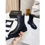 CHANEL puts on his boots with one foot